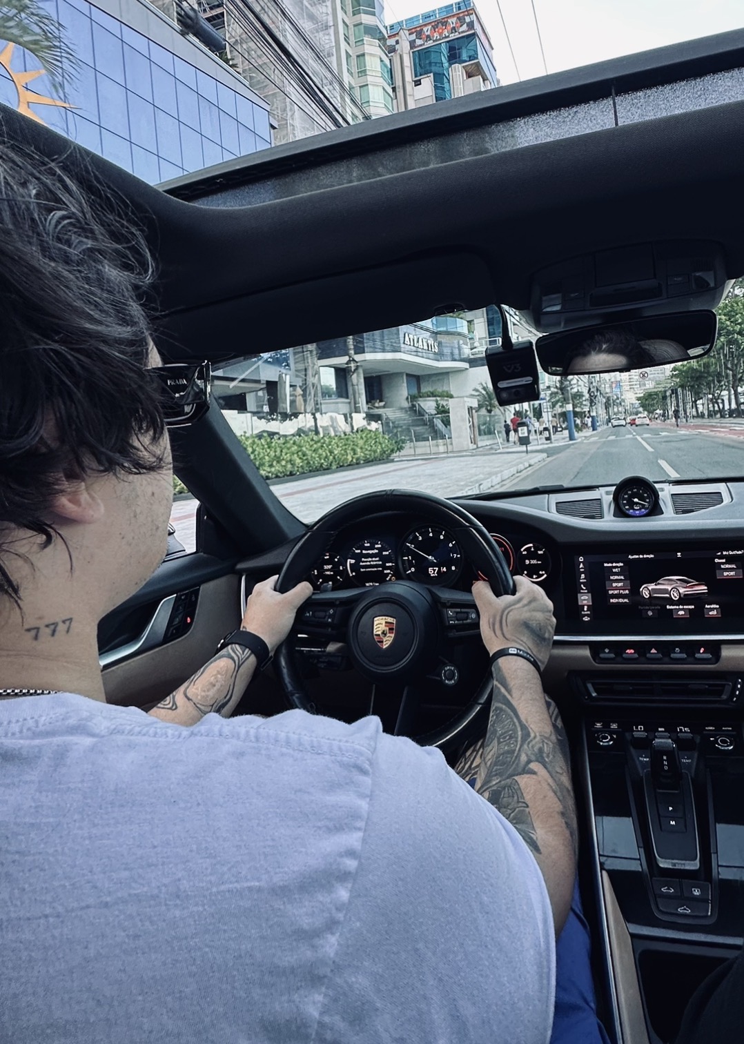 Masson dirigindo um Porsche 911 conversível pela avenida
