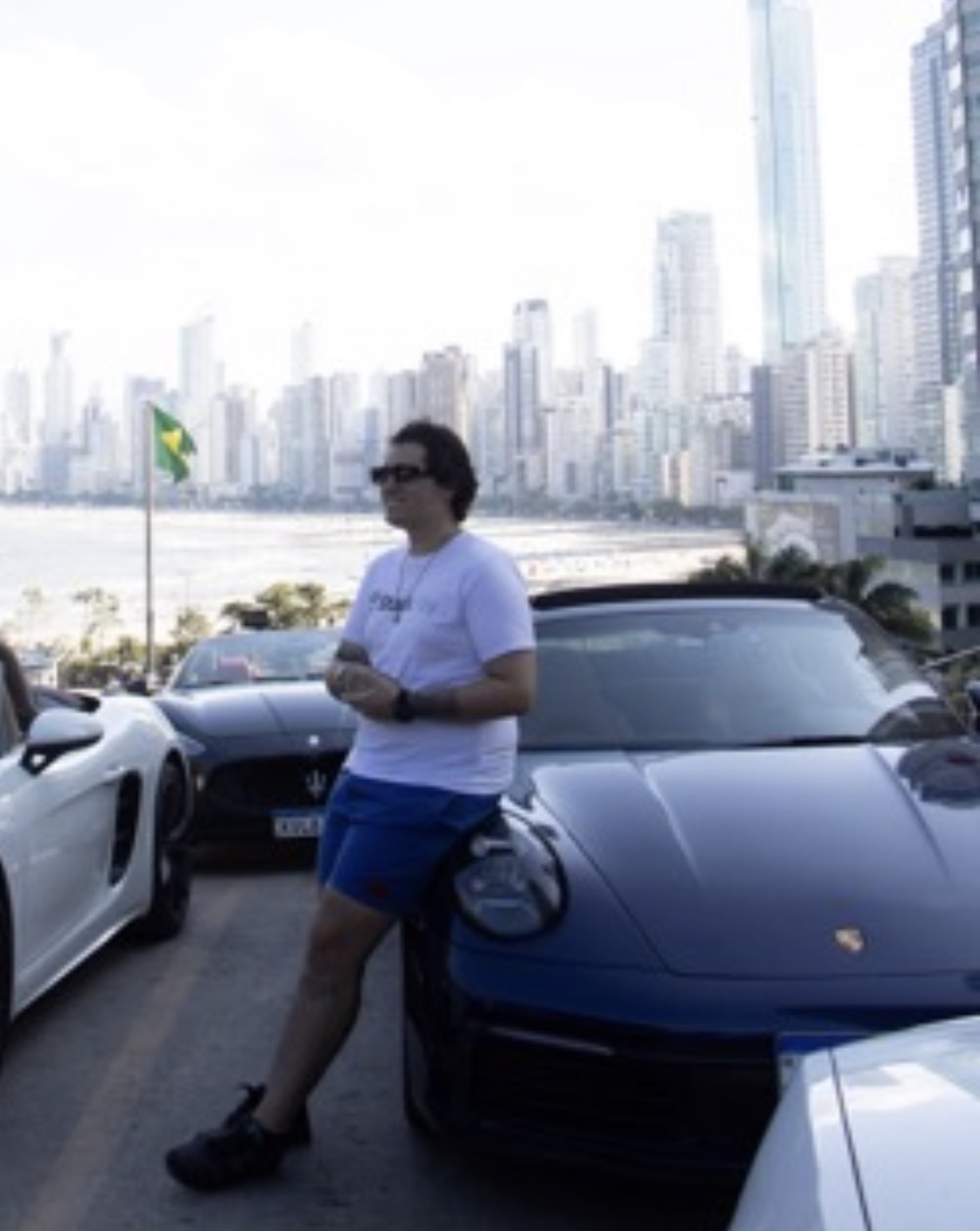 Masson em frente ao Porsche com a orla de Balneário Camboriú ao fundo
