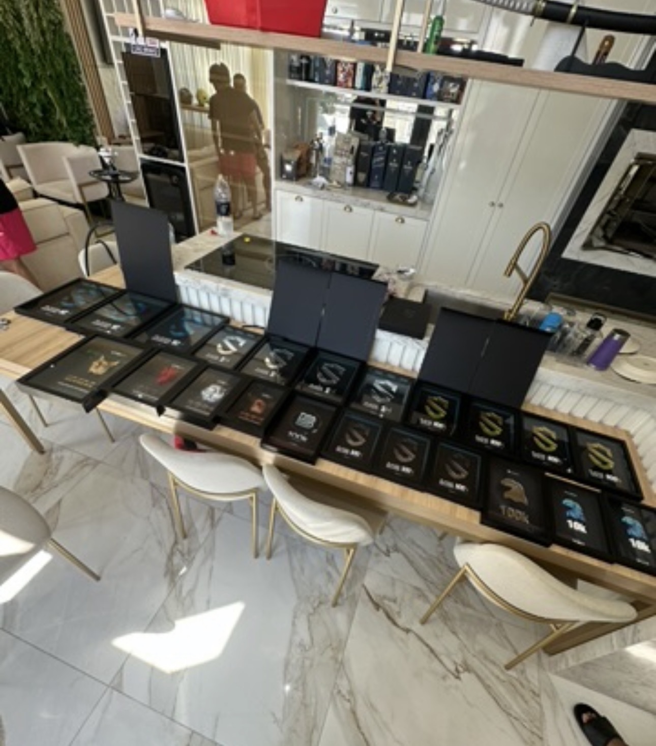 Mais de 20 placas de premiação sobre a mesa